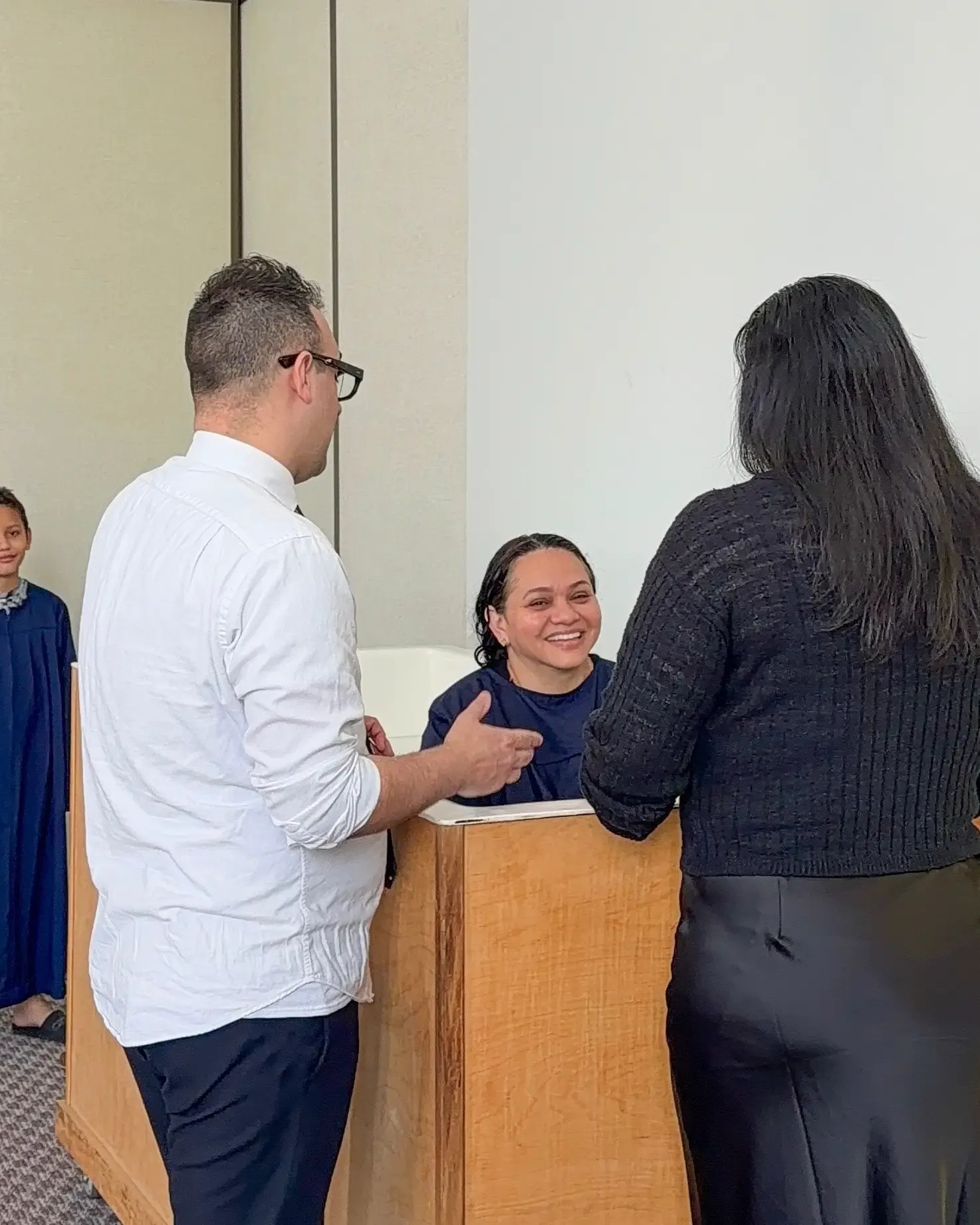 A baptism by immersion at AOR Church, with leaders praying over a new believer
