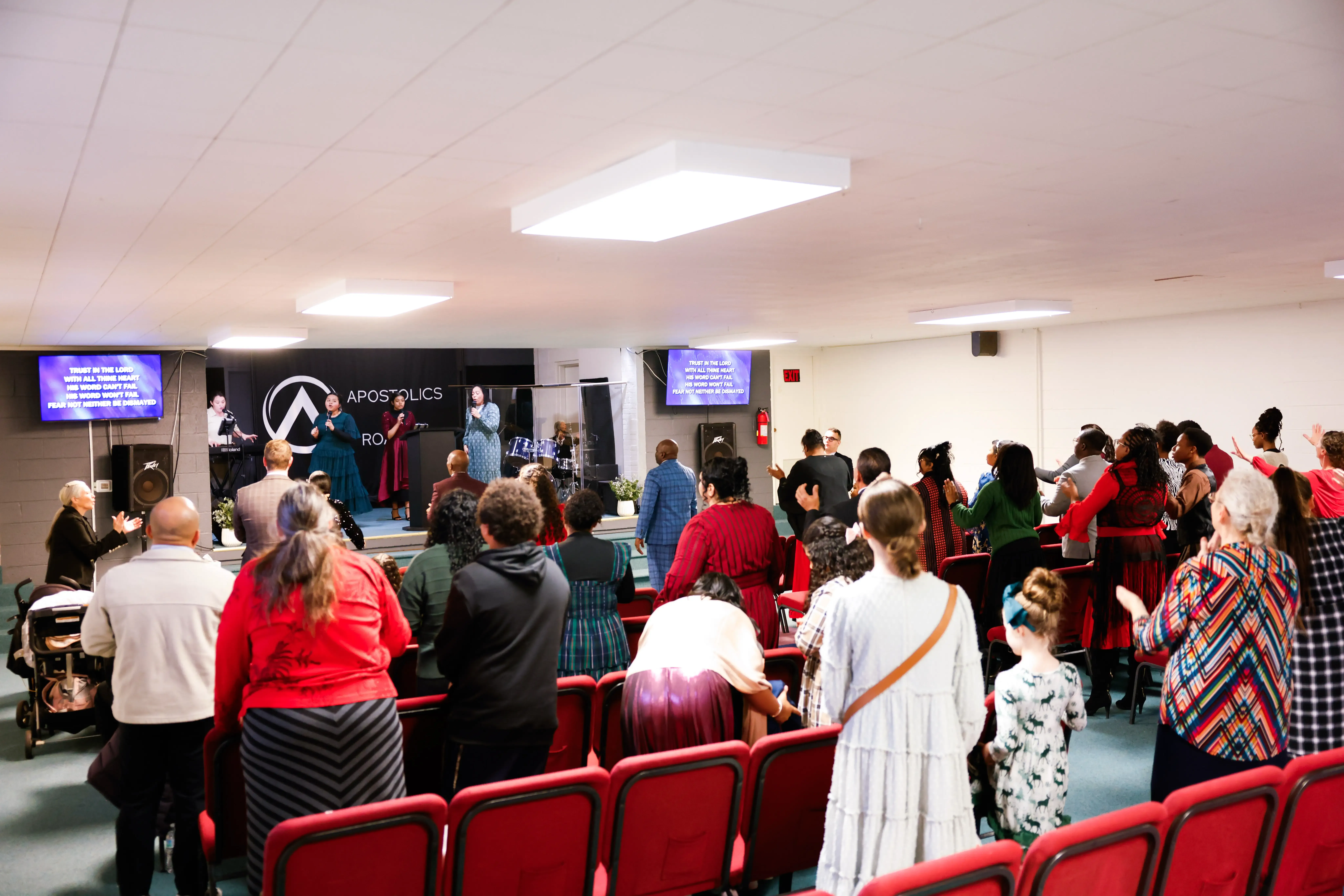 The AOR Church congregation worshipping together with hands raised during a Sunday service